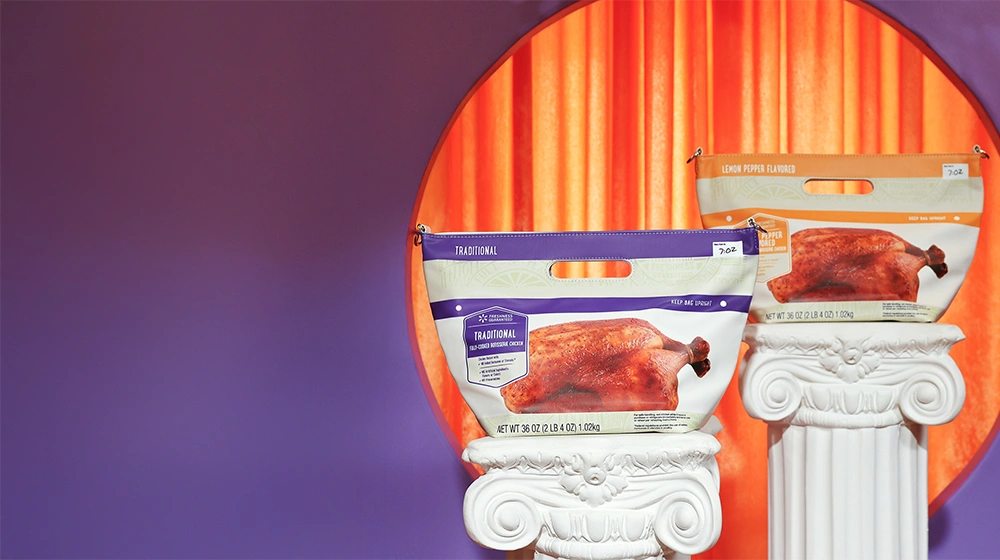 Two frozen turkey product bags are showcased on white classical-style pedestals. The bags feature roasted turkey imagery and are positioned in front of a circular orange curtain backdrop. The surrounding background is a smooth purple gradient, creating a bold contrast with the warm orange center. A small white rectangle with "5 lb" text is visible on the top right corner of each bag.