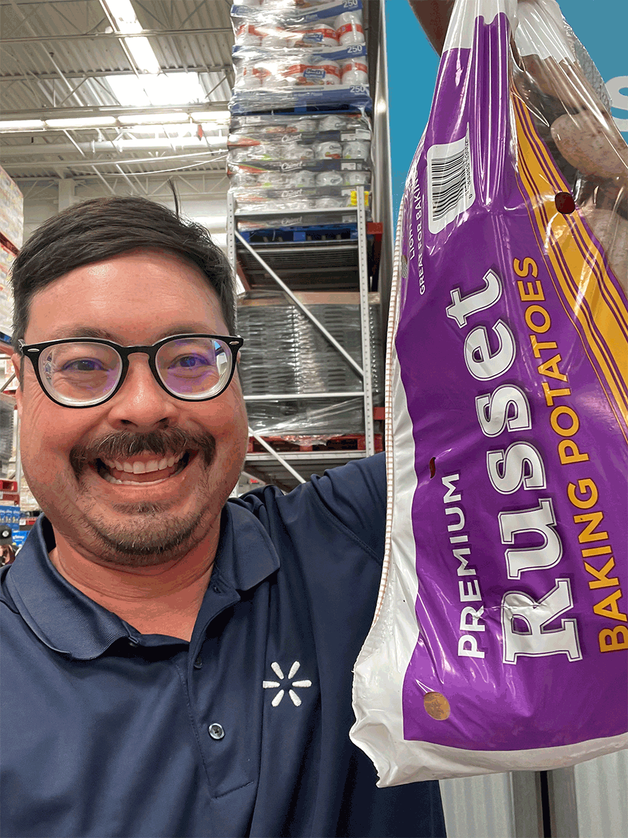 Chris holds up a bag of Russet potatoes. Look quick before he whips up a yummy side dish!
