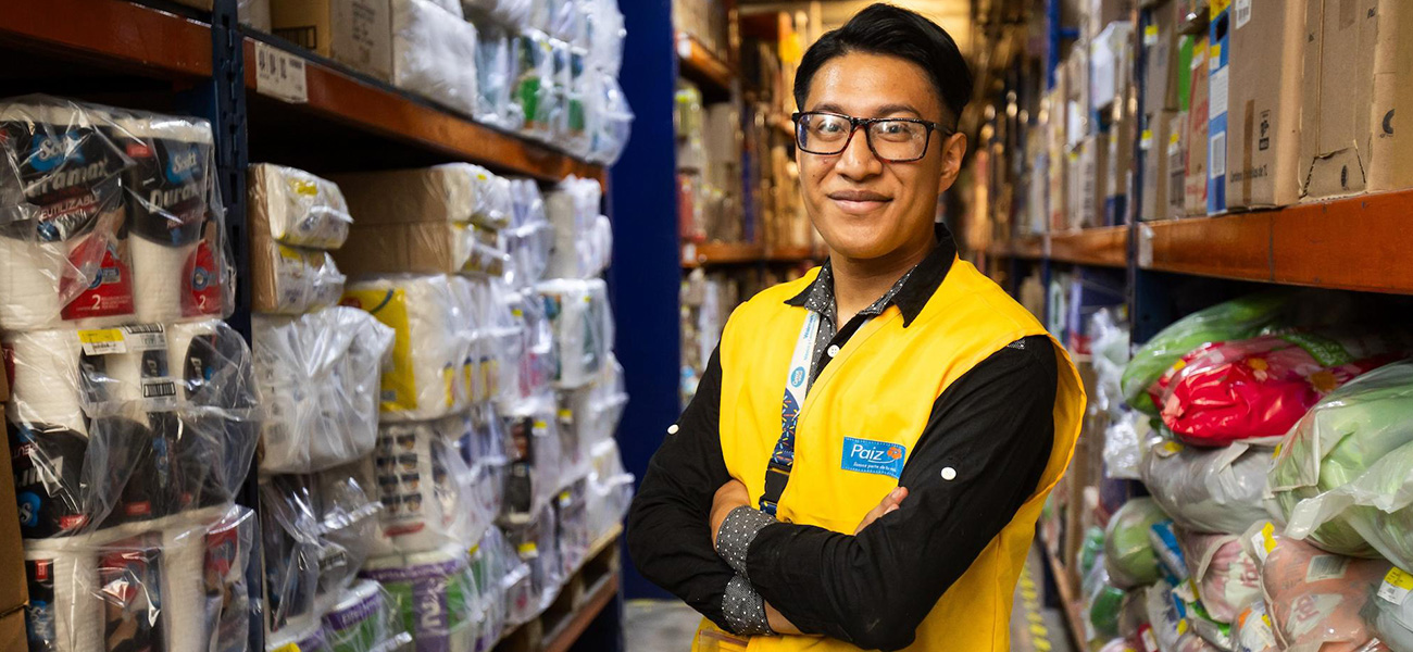 Paiz associate Edgar smiles with their arms crossed