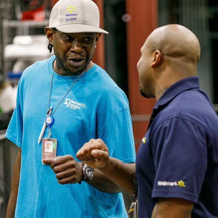 Walmart DC associate Kevin fist bumps another associate