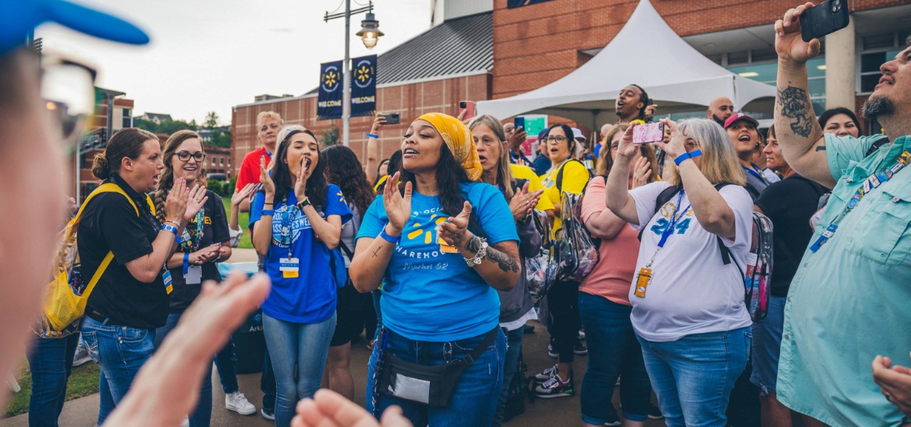 Associates clap, cheer and take pictures outside the Bud Walton Arena in Fayetteville, Arkansas, at 2024 Associates Week.