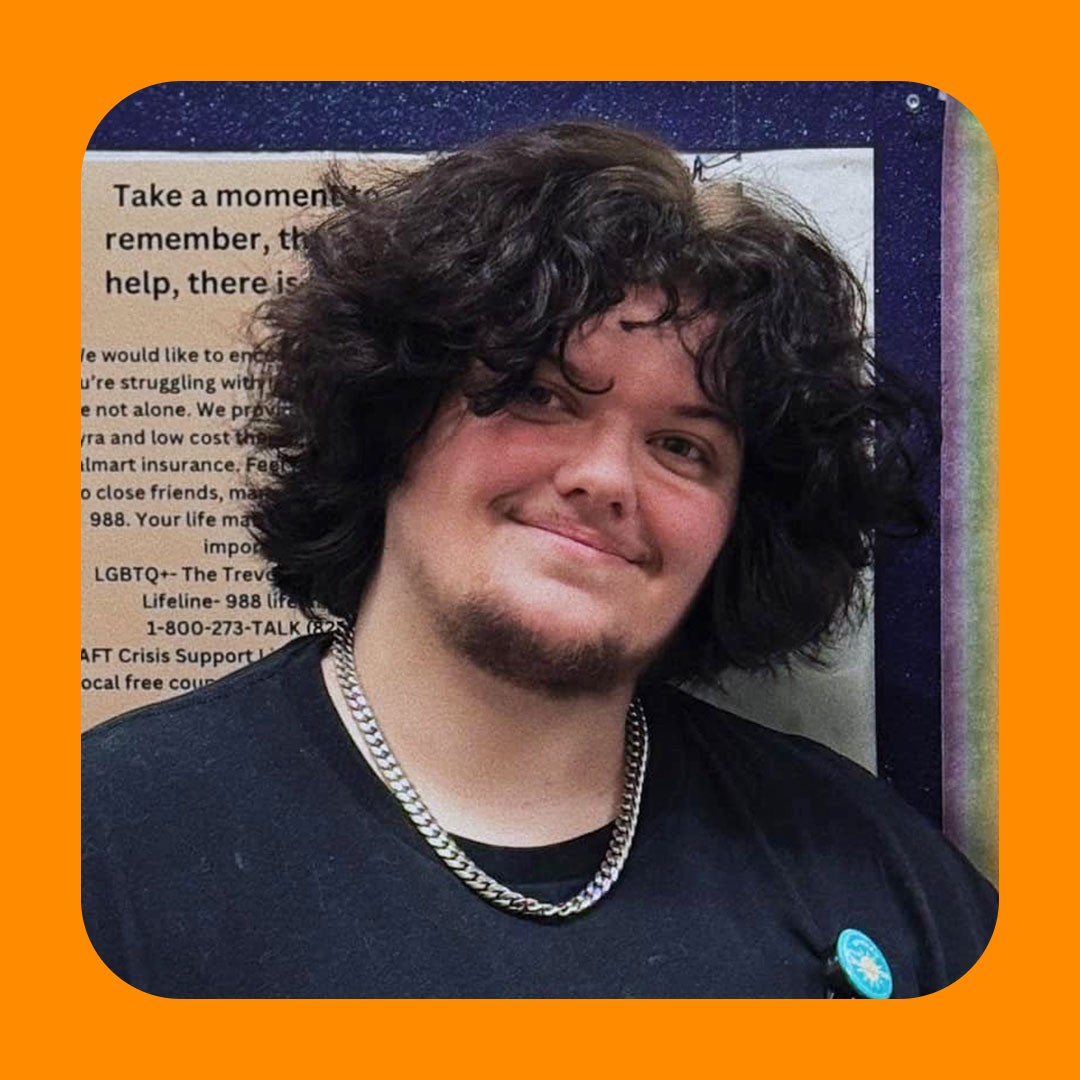 Walmart associate with dark hair smiles at camera.