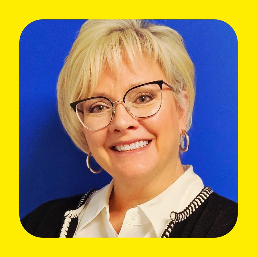 Walmart associate with blond hair and glasses smiles.