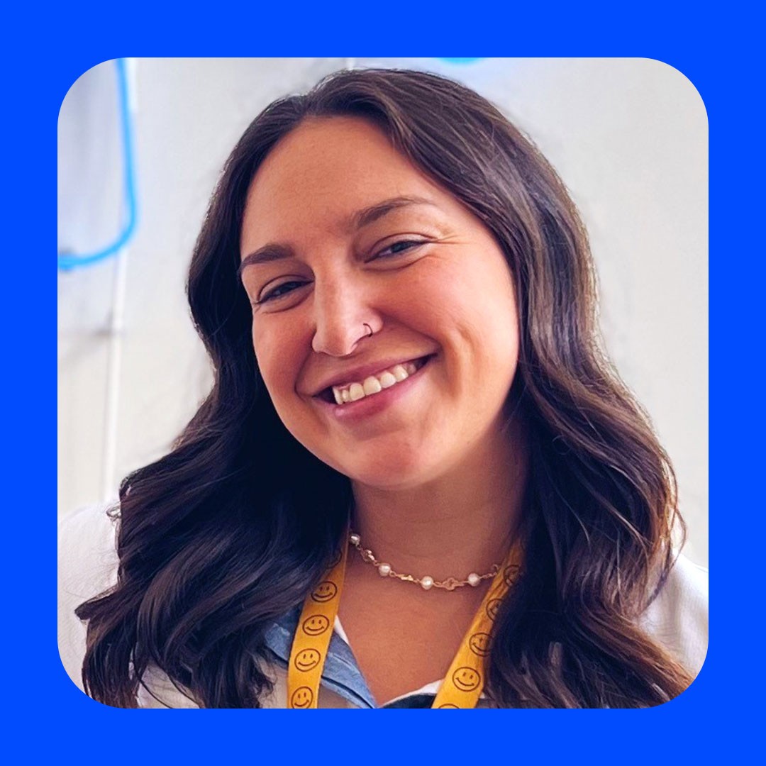 Walmart associate with long dark hair smiles at camera.