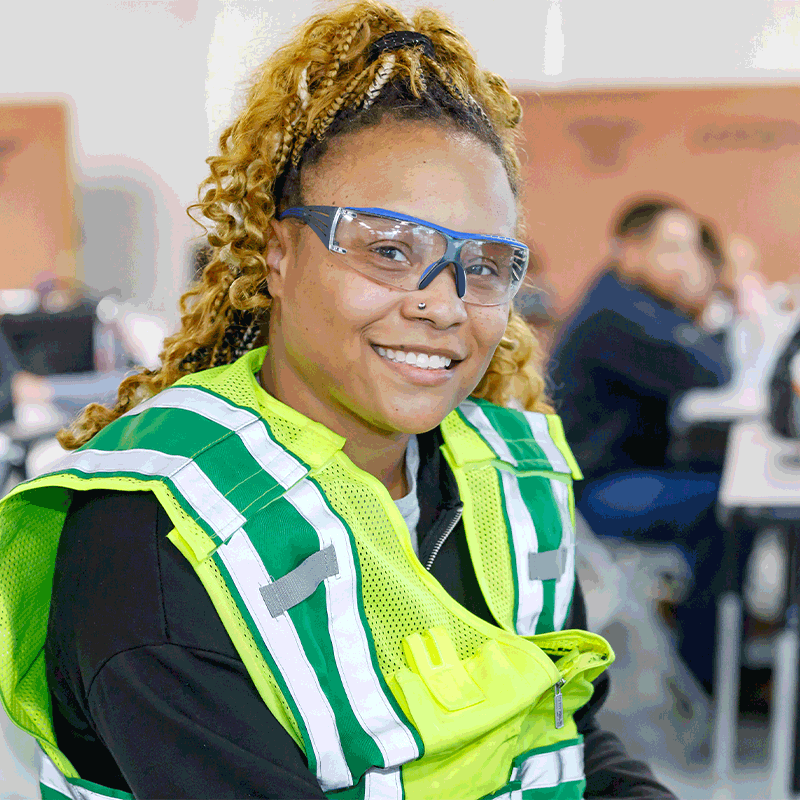 A Walmart associate in the Associate-to-Technician program smiles at the camera.